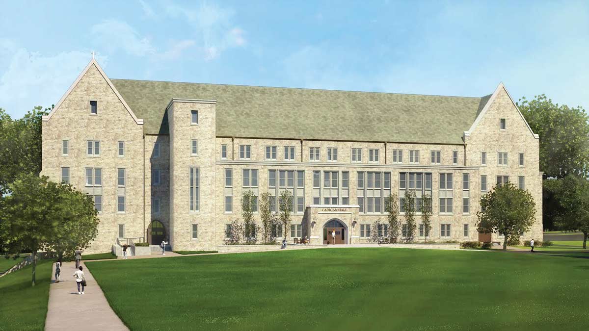 A large stone academic building with tall windows and a peaked roof sits behind a green lawn, with people walking on paths in front—perhaps reflecting on their journeys and preparing for the final Act of Gratitude that marks the culmination of their academic experience.