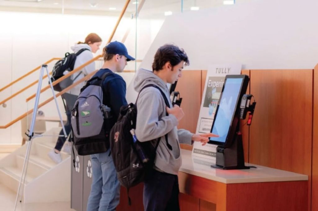 A student orders through a touchscreen kiosk in 245 Beacon Street.